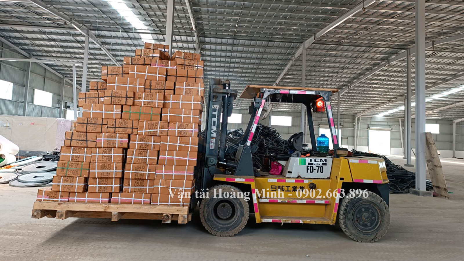 Nhân viên Hoàng Minh thực hiện nâng hạ hàng hoá cho khách hàng